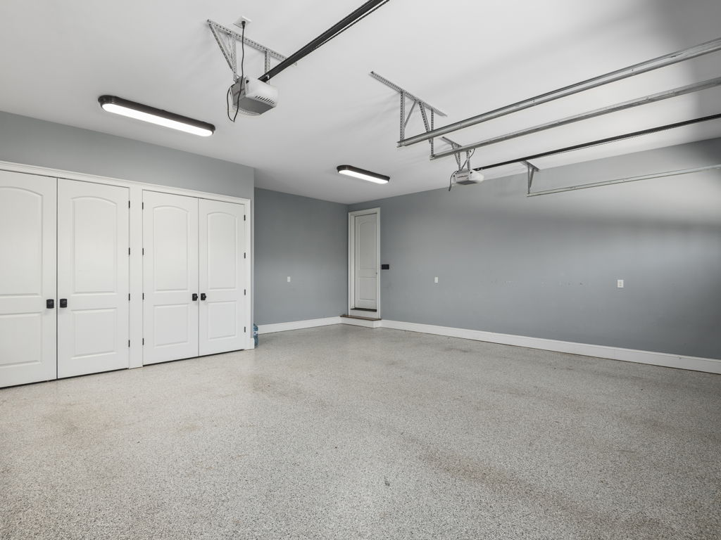 Spacious 3-car garage with pristine epoxy floors and built-in storage cabinets