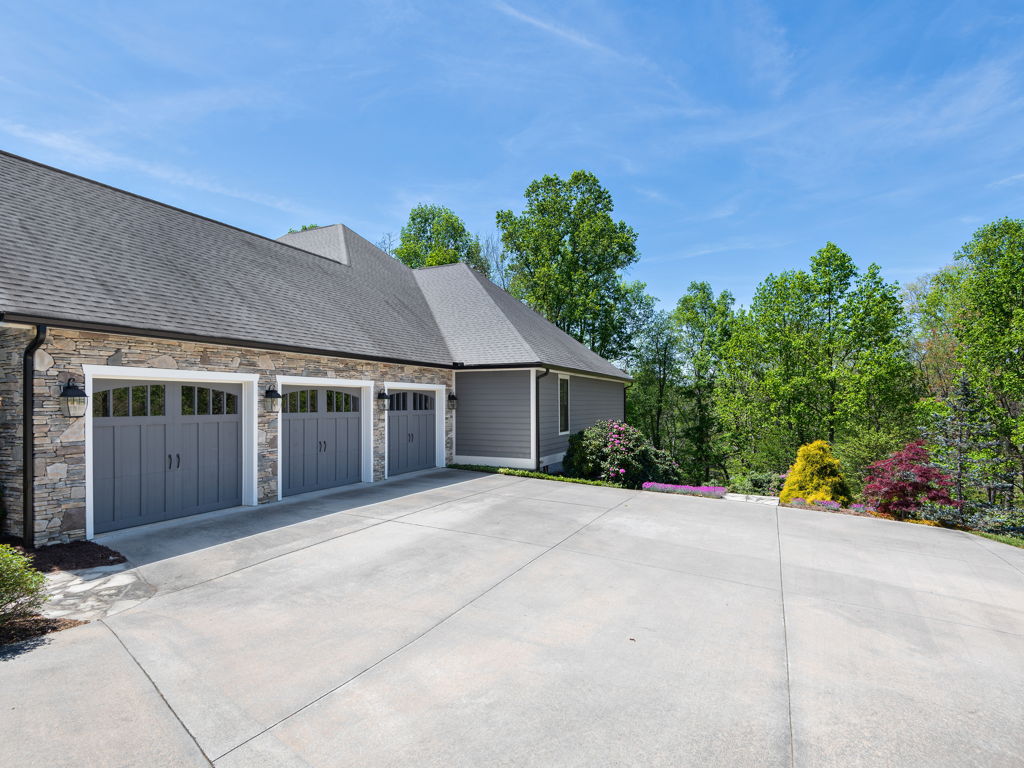 Side-entry garage courtyard with ample parking on asphalt drive