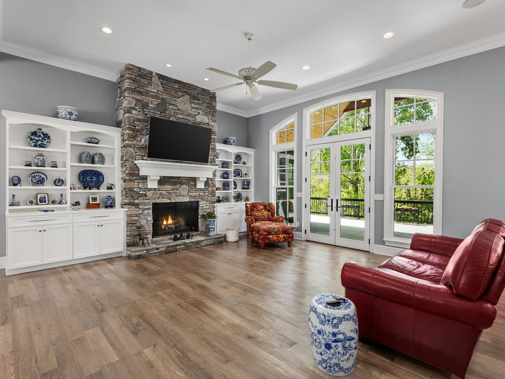 Soaring 12-foot ceiling great room with stone natural gas fireplace and custom built-in cabinetry