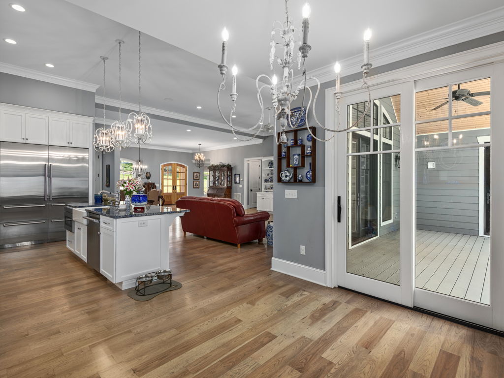 View from gourmet kitchen across to glass doors opening to covered outdoor deck
